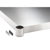 A close-up shot shows the corner of a 20 inches wide by 17 inches deep stainless steel work surface table shelf, with the "TRINITY" logo subtly visible on the side. Next to the corner are a cylindrical stainless steel leg component and a collection of silver screws and black plastic caps.