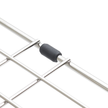 A macro shot highlights a small, black rubber bumper attached to the outer wire of a stainless steel sink grid. The bumper is designed to prevent the metal rack from scratching the sides of the sink.