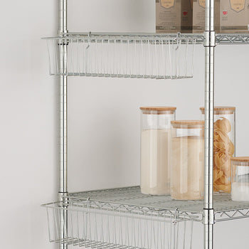 A close-up shows two wire hanging baskets attached to a chrome wire shelving unit against a light gray wall. The top basket is empty, while the lower basket is partially visible below a shelf holding glass jars with wooden lids and a smaller glass jar.
